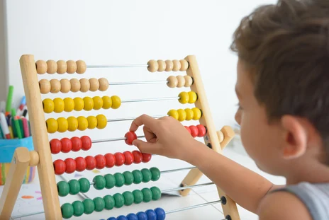 Ein junger Schüler benutzt einen Rechenschieber.