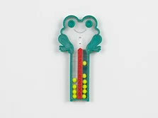 Zwei Plasteröhrchen, die von unten nach oben mit einer Skala von eins bis zehn nummeriert sind, auf dessen oberem Ende ein sitzender Plastikfrosch platziert ist. In den Plastikröhrchen befinden sich zehn Kugeln.
